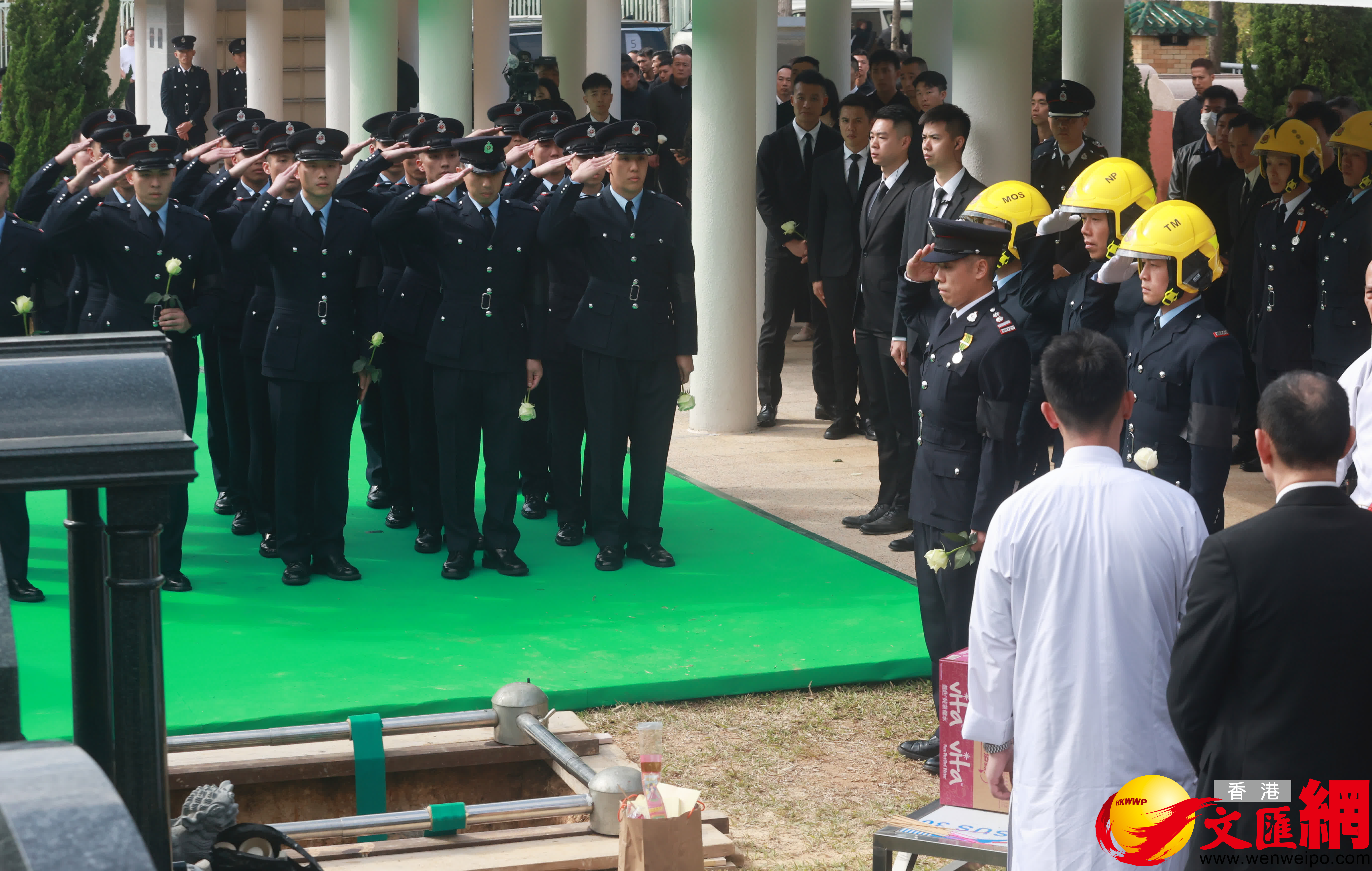 當靈柩被送下墓穴，親友及(ji)同袍最後輪流上前(qian)獻花(huā)，鞠躬緻意。（香港文(wén)匯報記者郭木(mù)又(yòu)攝）