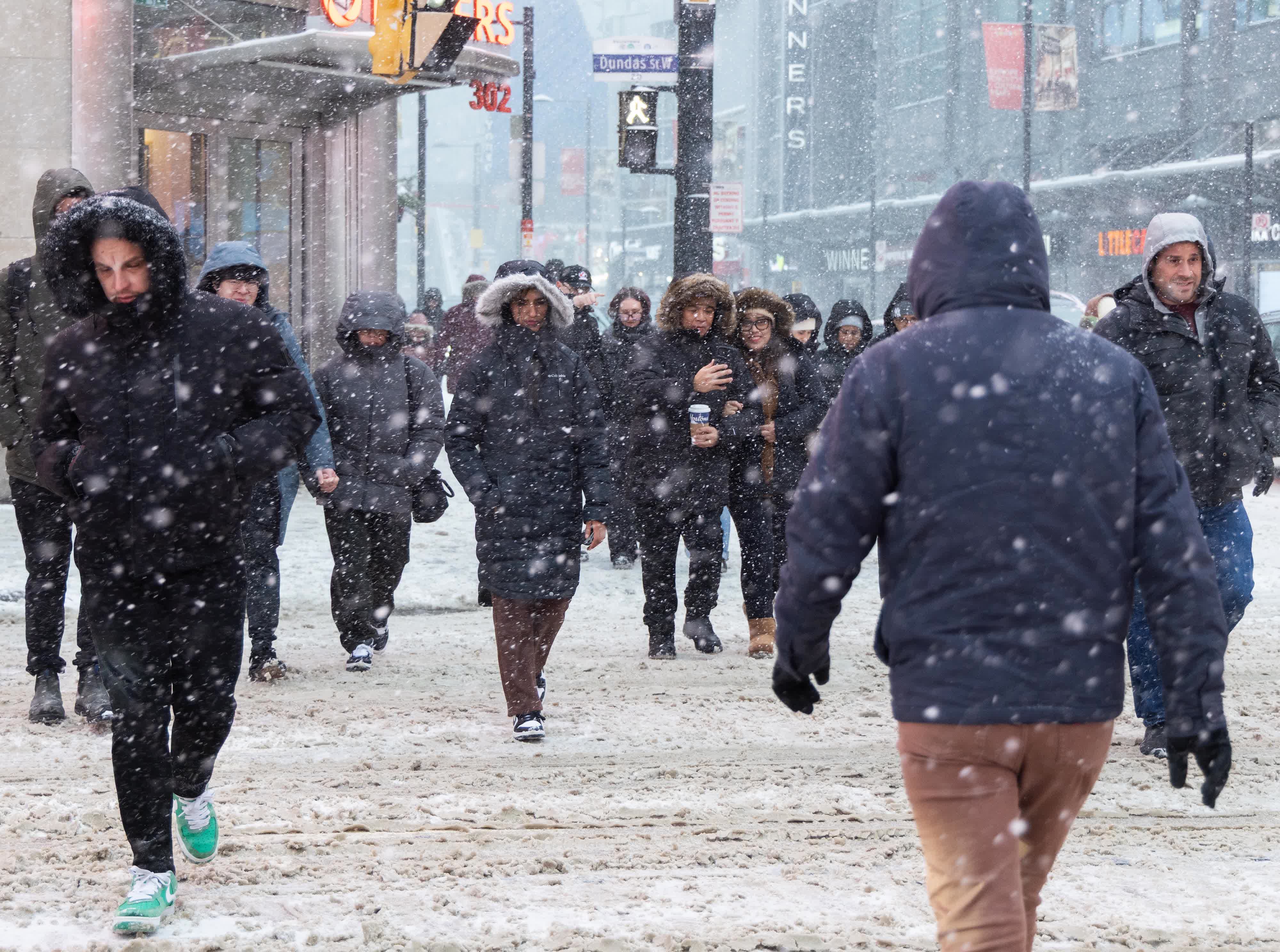 12月26日(ri)，在(zai)加(jia)拿(ná)大(da)多(duo)倫多(duo)，人(ren)們在(zai)風雪(xuě)中(zhong)出行。（新(xin)華社(she))）